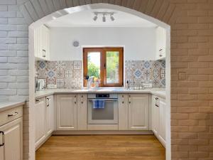 a kitchen with white cabinets and a window and an oven at Villa Golda in Petrovac na Moru
