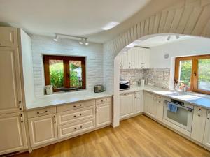 a kitchen with white cabinets and a brick wall at Villa Golda, The whole house Biker Friendly in Rijeka Reževići