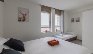 - une chambre blanche avec un lit et une fenêtre dans l'établissement Vacation Apartments In The Heart Of Nachlaot, à Jérusalem