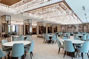 ein Esszimmer mit Tischen, Stühlen und Kronleuchtern in der Unterkunft Hotel Savior in Vaslui