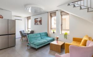 - un salon avec un canapé bleu et une table dans l'établissement Vacation Apartments In The Heart Of Nachlaot, à Jérusalem