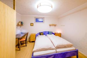 a bedroom with a bed and a table in it at Zum Engelreich ruhig, ländlich, stadtnah in Munich