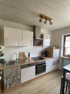a kitchen with white cabinets and a sink at Ferienhaus 40 in Egloffstein