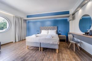 a bedroom with a bed and a blue wall at Island City Boutique Hotel in Rhodes Town