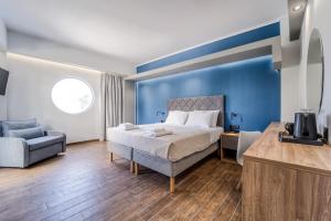 a bedroom with blue walls and a bed and a chair at Island City Boutique Hotel in Rhodes Town