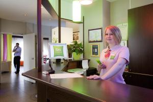 a woman standing at a desk in a office at ibis Styles Belfort Centre in Belfort