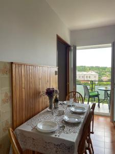 a dining room table with a white table cloth and chairs at Apartment " So" in Senj