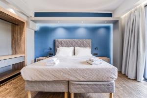 a bedroom with a large bed with blue walls at Island City Boutique Hotel in Rhodes Town