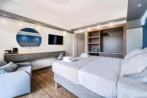 ein Hotelzimmer mit einem Bett und einem Sofa in der Unterkunft Island City Boutique Hotel in Rhodos (Stadt)