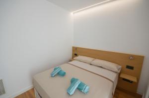 una camera con un letto e due pantofole blu di Suites Port Cambrils a Cambrils