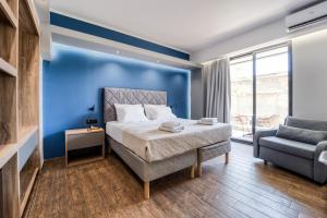 a bedroom with a blue wall and a bed and a chair at Island City Boutique Hotel in Rhodes Town