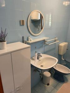 a bathroom with a sink and a mirror and a toilet at Apartment " So" in Senj +12 photos