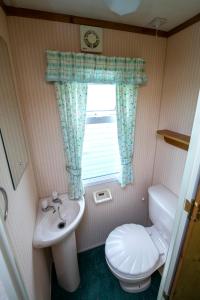 a small bathroom with a toilet and a sink at Domki Alfa in Kopań +73 photos