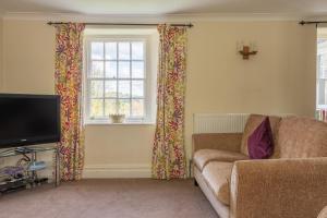 a living room with a couch and a television at Hilltop in Far Sawrey