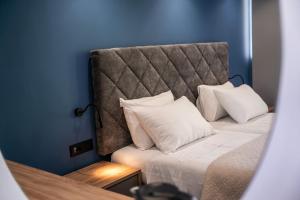 a bed with white pillows in a blue room at Island City Boutique Hotel in Rhodes Town