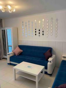 a living room with a blue couch and a table at Апартаменты 1+1 с выходом на бассейн in Kemer