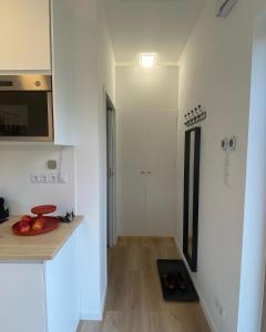cocina con paredes blancas, suelo de madera y mesa en Tiny House 47 en Egloffstein