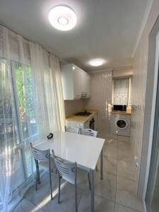 a kitchen with a white table and two chairs at Апартаменты 1+1 с выходом на бассейн in Kemer