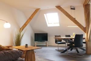 a living room with a table and a tv at FEWO Leuchtturmidyll Harriersand in Schwanewede +22 photos