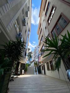 an empty alley between two buildings with palm trees at Parfe Apart in Trabzon