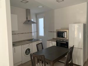 a kitchen with a table and a stove and a refrigerator at Blanco y Tinto in Logroño