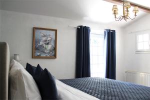 una camera da letto con un letto con tende blu e un lampadario a braccio di Les Rocailles a Lamonzie-Montastruc