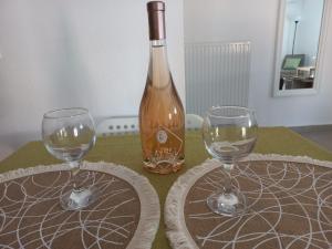 two wine glasses on a table with a bottle of wine at Comfy and Izzy apartment in Karlovasi