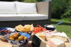 una tavola ricoperta di ciotole di formaggio e altri alimenti di Les Rocailles a Lamonzie-Montastruc