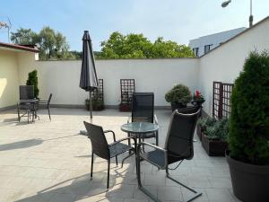 patio con tavolo, sedie e ombrellone di Villa Orłowska Apartamenty a Gdynia