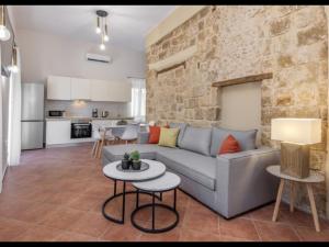 a living room with a couch and a stone wall at Nikolas Old Town in Rhodes Town
