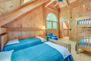 1 dormitorio en una cabaña de madera con cama y escalera en Lakefront Westhampton Cabin with Beach and Kayaks!, en Westhampton