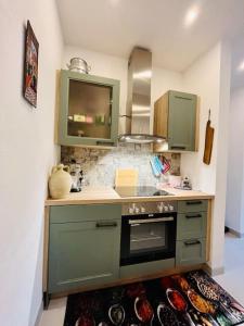 cocina con armarios verdes y fogones en Landhaus Appartment en Pettnau