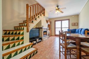 a dining room and living room with a spiral staircase at Casa Manolo in Torredembarra