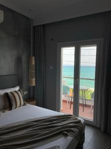 a bedroom with a bed and a view of the ocean at Xenios Hotel in Pefkochori