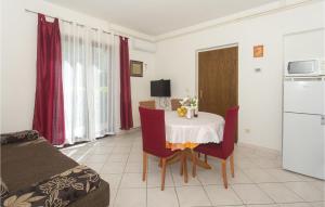 a room with a table and chairs and a kitchen at Nice Apartment In Podstrana With 1 Bedrooms And Wifi in Podstrana