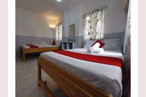 um quarto com uma cama grande com lençóis vermelhos e brancos em OYO 449 Sunrise 888 em Oslob