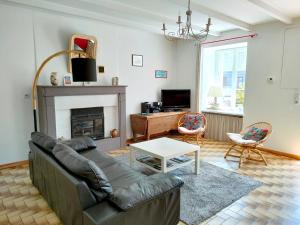 a living room with a couch and a fireplace at Maison de charme au Vivier-sur-Mer avec terrasse privée in Le Vivier-sur-Mer