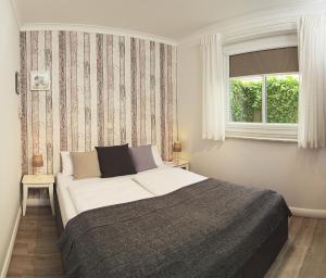 Un dormitorio con una cama grande y una ventana en Haus Ferienidyll, en Ahlbeck