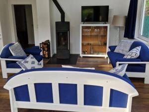 sala de estar con muebles azules y blancos y chimenea en Ferienhaus Am See 19, en Zehdenick