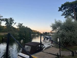 Ein Boot liegt an einem Dock auf einem Fluss. in der Unterkunft Riverside 2 Bed Cabin With Paddle Boards & Bikes in Bristol