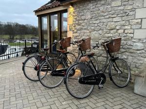 two bikes parked in front of a stone building at Riverside 2 Bed Cabin With Paddle Boards & Bikes in Bristol