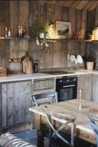 een keuken met een houten tafel en een tafel en stoelen bij Riverside 2 Bed Cabin With Paddle Boards & Bikes in Bristol