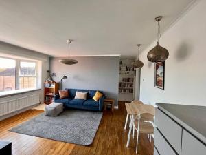 a living room with a blue couch and a table at Charming 1 bedroom apartment in Rottingdean in Rottingdean