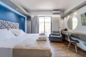 a bedroom with a large bed and a chair at Island City Boutique Hotel in Rhodes Town