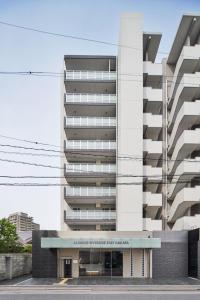 un edificio con un estacionamiento delante de él en ALFACIO RIVERSIDE STAY HAKATA, en Fukuoka