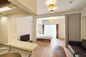 福岡的住宿－ALFACIO RIVERSIDE STAY HAKATA，客厅配有沙发和1张床