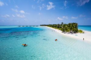 eine Luftansicht auf einen Strand mit zwei Booten im Wasser in der Unterkunft Riu Atoll-All Inclusive in Dhaalu Atoll