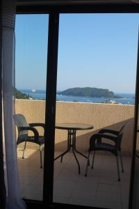 een tafel en stoelen op een balkon met uitzicht op het strand bij MIA CASA Apartmens in Budva