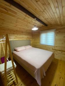 a bedroom with a bed in a wooden cabin at Yildiz Ahşap Evleri in Datca