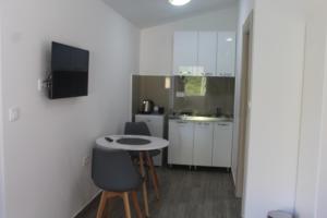 una piccola cucina con tavolo e sedie in camera di MIA CASA Apartmens a Budua